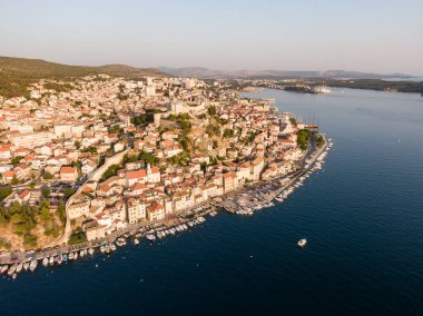 Hırvatistan 'ın Sibenik kenti üzerinde gün batımını gösteren hava dronw görüntüsü. Deniz kenarında limanı olan antik ve eski kasaba kıyıları. Şehrin yukarısındaki kale. Hırvatistan 'ın ünlü turizm beldesi.