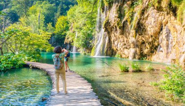 Plitvice, Hırvatistan - 21.7.2021: Turistler güzel doğa parkı, Plitvice gölleri ve şelaleleri ziyaret ediyorlar. Meşhur seyahat yeri, saf doğada tatlı su..
