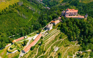 Aerial drone fly near the Pernstejn castle, Czech Republic. Vysocina region near the Nedvedice village. Summer day with sun and blue sky. Green nature and fresh forest.