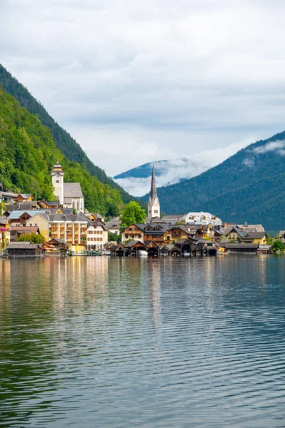 Hallstatt Village ve Hallstatter. Avusturya 'da göl. Göl kenarındaki ünlü eski kilisenin manzarası. Arka plandaki dağların üzerinden bulutlar ve sis. Ünlü turizm beldesi.