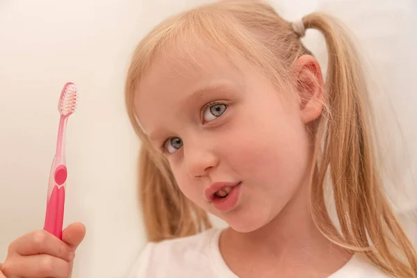 Blank meisje in t-shirt, poetst haar tanden met tandenborstel, close-up portret — Stockfoto