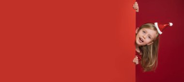 Fotokopi alanı olan kırmızı bir Noel. Gülen mutlu kızın yüzü