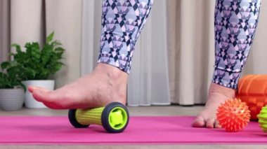 Evinde kendine miyofasyal masaj yapan bir kızın ayaklarına yakın çekim.