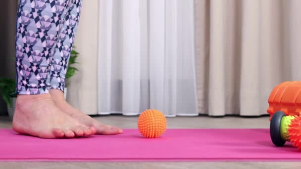 Femme sur tapis de yoga se massant avec une boule piquante — Video