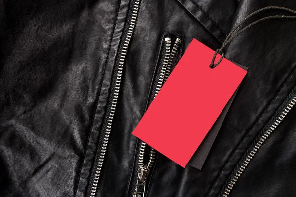 Etiqueta vacía para texto en color rojo sobre cuero chaqueta negra con cerraduras metálicas — Foto de Stock