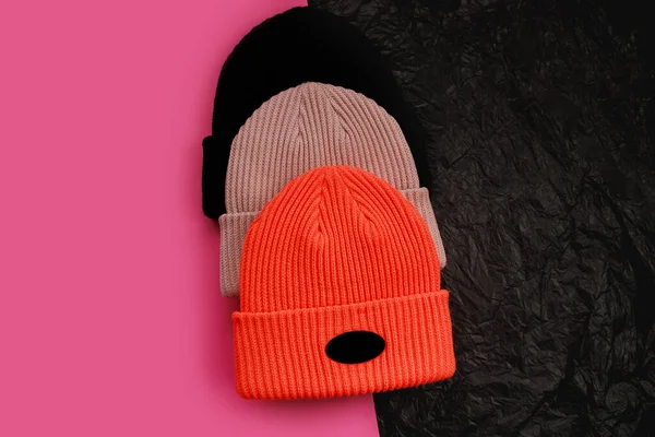 三顶不同颜色的帽子，带有粉红色背景的标签 — 图库照片