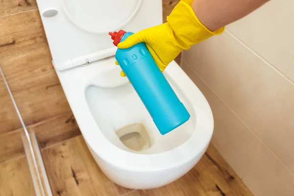 Primer plano de las manos usando solución de limpieza de inodoro desinfectante mockup botella azul — Foto de Stock