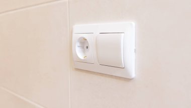 beyaz elektrik prizi ve ışık düğmesi beyaz bir duvara yakın çekim, kopyala