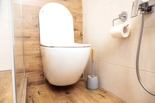 Interior de una habitación sanitaria con un inodoro y una ducha higiénica de primer plano, en colores naturales — Foto de Stock