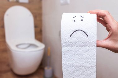 Banyonun arka planındaki tuvalet kağıdına komik bir yüz çizilmiş.