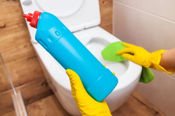 Primer plano de las manos usando solución de limpieza de inodoro desinfectante mockup botella azul — Foto de Stock