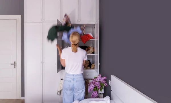 woman is going to put things in order in a white closet with clothes, copy paste