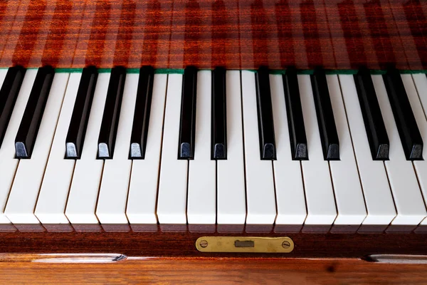 Yakın plan, kahverengi piyano. Piyano tuşları siyah ve beyaz, üst görünüm, düz güneş. Müzik eğitimi konsepti. Arkaplan, afiş veya afiş için kapak