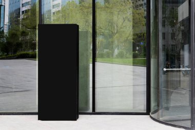 Büyük cam kapıların yanındaki bir restoran ya da otel için sokak tabelası. İş binası, otel, restoran, konut kompleksi tabelası. Şehri yansıtan büyük cam bir vitrin.