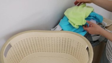 Kirli çamaşırları toplayıp bir lavaboya koyan bir kadının ellerine yakın çekim. Kadınların ev işleri, çamaşır yıkama tozu, çamaşır yıkama, çamaşır yıkama. Ev işleri, günlük işler.