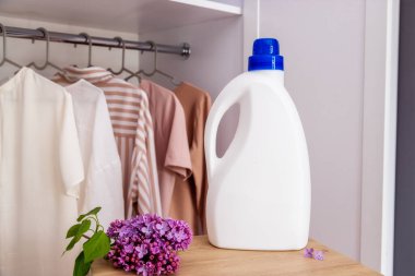 Boş Şişelerin Eko Tasarım Mockup 'ı Renksiz Giysilerle Dolaplar Arkaplanına Karşı Dolapta Deterjan Paketleme. Mesaj için yer. Biyolojik organik ürün. Leylak dalı, taze koku.
