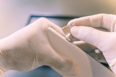 Adamın eli lastik korumalı, personelin SIM kartı değiştirmesi müşterilerin alabileceği bir mağazada seyahat simülasyonu satması, Coronavirus enfeksiyonunu önlemek için 4K ölçü - 19.