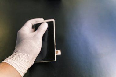 Adamın eli lastik korumalı, personelin SIM kartı değiştirmesi müşterilerin alabileceği bir mağazada seyahat simülasyonu satması, Coronavirus enfeksiyonunu önlemek için 4K ölçü - 19.