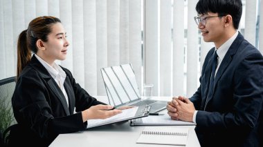 İş görüşmesine giderken profilini ve geçmiş iş tecrübesini işverenine açıklayan Asyalı bir kadın.  