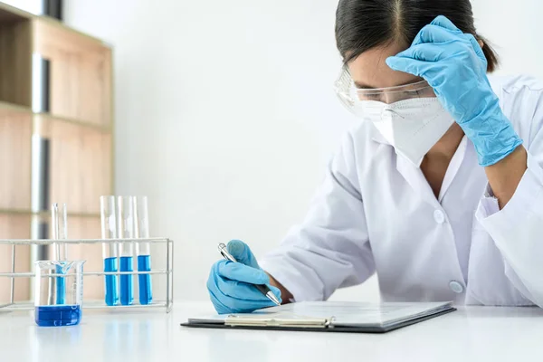 Tıbbi Maskeli Kadın Bilim Adamı Test Tüpünde Mavi Bir Sıvıya — Stok fotoğraf