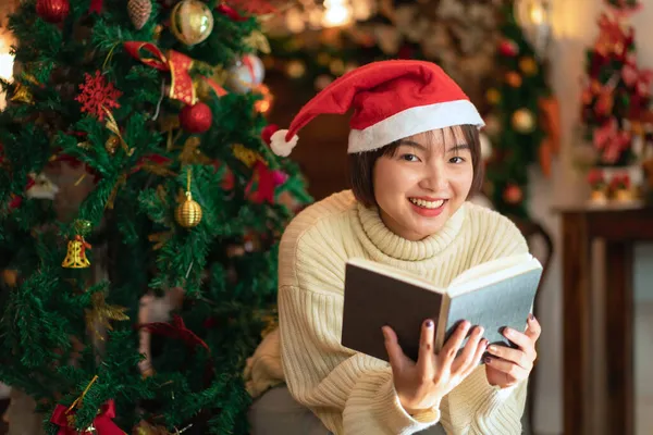 Hermosa Mujer Sombrero Santa Está Sonriendo Leyendo Libro Delante Del —  Fotos de Stock