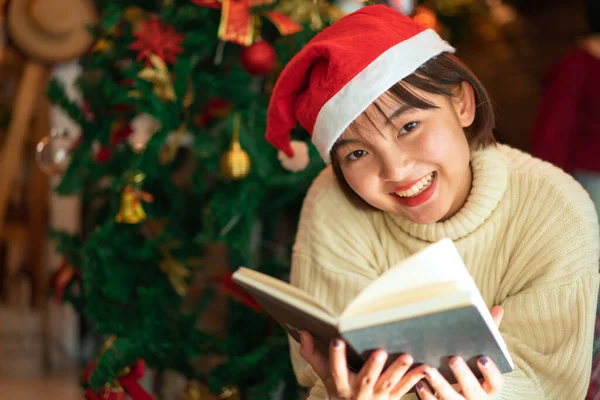 Hermosa Mujer Sombrero Santa Está Sonriendo Leyendo Libro Delante Del —  Fotos de Stock