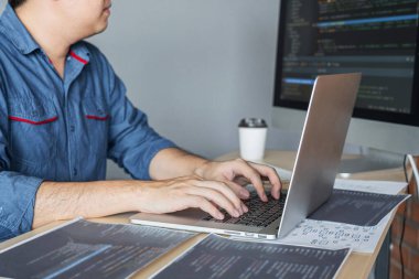 Bir yazılım geliştirme ofisinde çalışan, kod yazan ve veri kodu yazan, HTML, PHP ve javascript ile programlanan genç Profesyonel programcı.