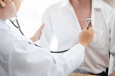 Doktor kalp atışlarını steteskopla dinleyip kalp atış hızı muayenesi, sağlık ve sağlık sigortası konseptini teşhis etti..