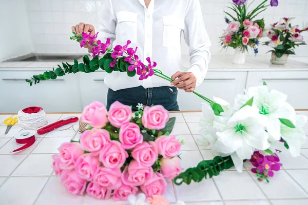 自宅で人工的な花の装飾を配置し 若い女性の花屋の仕事は 組織を作る汚い人工的な花 工芸品や手がコンセプトを作った — ストック写真