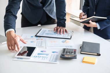 İş dünyası ekibi liderleri, meslektaşlarına sunum ve iş stratejisi üzerinde çalışıyor ve bir tartışma yapıyorlar, grafik ve grafiğe işaret ederek, işbirliği ortaklığının başarısına işaret ediyorlar..