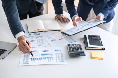 İş dünyası ekibi liderleri, meslektaşlarına sunum ve iş stratejisi üzerinde çalışıyor ve bir tartışma yapıyorlar, grafik ve grafiğe işaret ederek, işbirliği ortaklığının başarısına işaret ediyorlar..