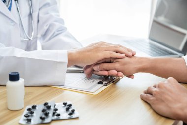 Doktor hastayı cesaretlendirmek ve empati kurmak için hasta ellerine dokunuyor, hastaya tezahürat ve destek veriyor, tıbbi muayene, güven ve etik.