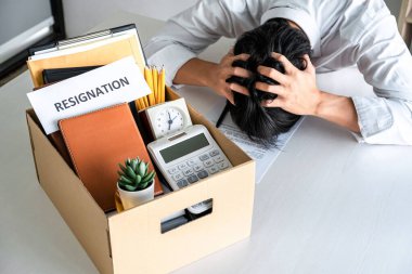 Tüm kişisel eşyalarını ve dosyalarını kahverengi bir karton kutuya koyan İşadamı, istifa etmek ve ofiste iptal sözleşmesi imzalamak için sinirlendi ve vurguladı..