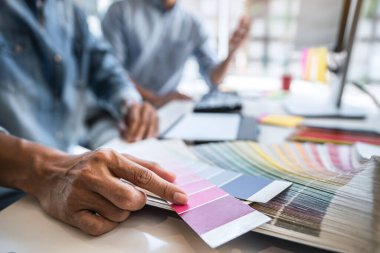 Yaratıcı bir proje üzerinde birlikte çalışan genç iş arkadaşları ve renk örnekleri, renk örnekleri, Beyin Fırtınası Planlama Ortaklığı, masaüstünde çalışan yaratıcı grafik tasarımı.