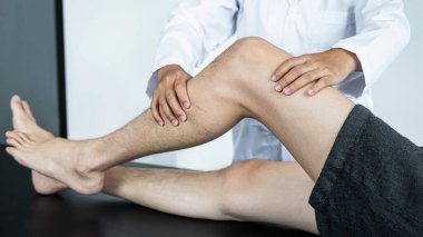 Tedavi ve rehabilitasyon yapan kadın fizyoterapist, hastanın dizini esneterek ve sağlık kliniğinde fizik egzersiz yaparak yaraladı.