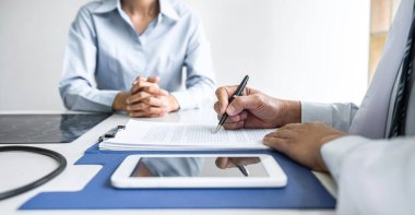 Profesör Doktor bir şeyi tartışıp tedavi yöntemleri öneren, rapor ve röntgen filmleri, tıp ve sağlık hizmetleri konseptinin sonuçlarını sunan bir hastaya danışmanlık yapıyor..