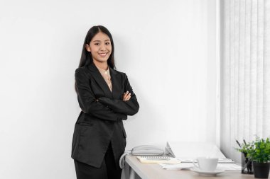 İş kadını, ofisteki işyerindeki yatırım analizinden sonra gülümseyip kameraya bakıyor.