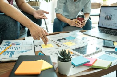 Birlikte çalışan iş ortağı profesyonel ekip, ofiste yeni bir pazarlama başlatma projesi stratejisi ile verileri istişare ve analiz etmektedir.