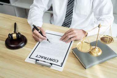 Mülk davasının evrakları, hukuk kitapları ve masa başında ahşap tokmakla çalışan erkek avukat..