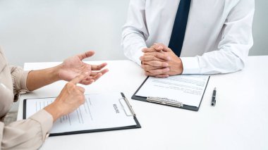Kadın işveren, adayların sorularını soruyor ve iş görüşmesine başvururken iş tanımı hakkında açıklama yapıyor.
