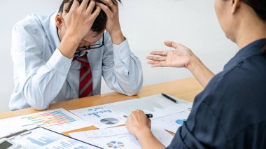 Erkek çalışan, yöneticinin iş belgesini kontrol etmesi ve ofis toplantısı sırasında yapılan işten şikayet etmesi üzerine başarısız proje yüzünden stres altında.
