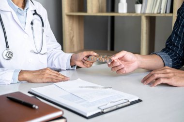 Hastalığın belirtilerini tartışan ve tedavi yöntemleri öneren, rapor ve reçete, tıp ve sağlık hizmetleri kavramının sonuçlarını sunan doktor danışmanlık hastası.