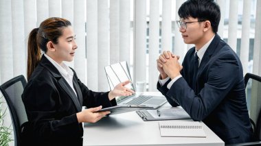 İş görüşmesine giderken profilini ve geçmiş iş tecrübesini işverenine açıklayan Asyalı bir kadın.  