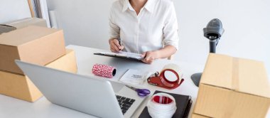 Genç girişimci KOBİ sipariş istemcisi alır ve satın alma siparişi ve paket ürünü, nakliye için küçük işletme paketi hazırlama çevrimiçi pazarda ambalaj kutusuyla birlikte çalışır.