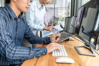 İşletme tüccarları borsayı online olarak kontrol ediyorlar. Laptop ekranındaki grafik verilerini analiz ediyorlar. Ofiste birlikte çalışırken online alım satım hakkında beyin fırtınası yapıyorlar..