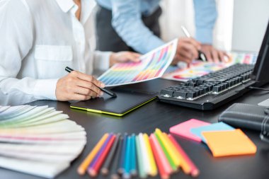 Renk seçimi ve grafik tablet üzerinde çalışan iki yaratıcı grafik tasarımcı ekibi, iş yerindeki yaratıcılığa ilham vermek için renk örneklerinin şeması.