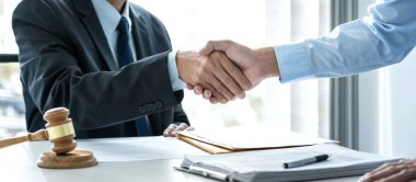 Profesyonel avukat, mahkeme salonunda iyi bir anlaşma yaptıktan sonra bir işadamını tebrik ediyor..