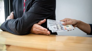 İşadamı, arazi ve gayrimenkul satın alımıyla ilgili yolsuzluk yaparken, sözleşmeyi imzalayan işverenden banknot parası ve sözleşmenin şartlarını alır.