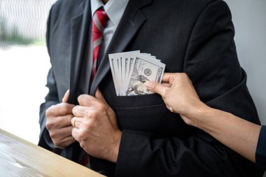 İşadamı, arazi ve gayrimenkul satın alımıyla ilgili yolsuzluk yaparken, sözleşmeyi imzalayan işverenden banknot parası ve sözleşmenin şartlarını alır.