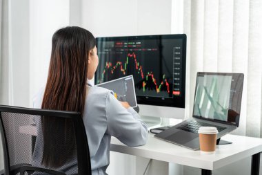 Bilgisayar, tablet ve grafik borsası planlama ve grafik veri yatırım planlama ile çalışan iş kadını yatırımcı.